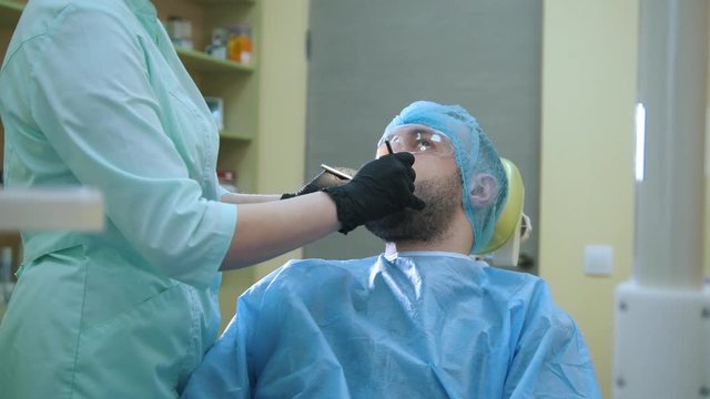 Doctor and patient in the dental office, examination man's mouth