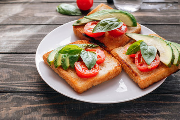Dietary healthy food. Bread with avacado, tomatoes and Basil