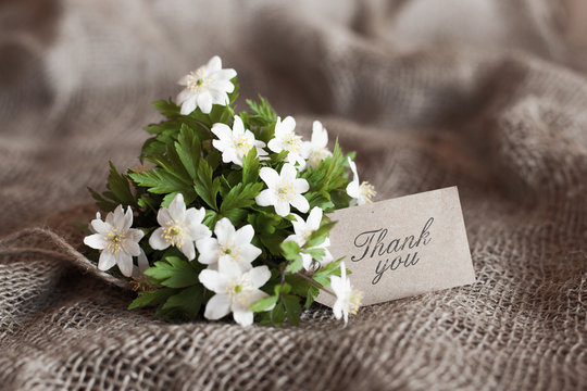bouquet of spring anemones with a "thank you" card