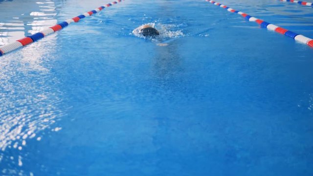 A front slow motion shot of a swimmer making a crawl stroke. 