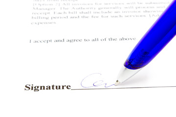 Pen writes signature on white paper