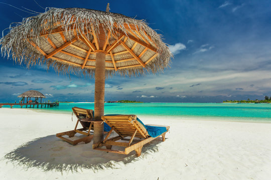 Two chairs and umbrella on stunning tropical beach, Maldives