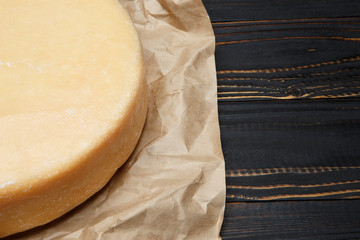 Whole round Head of parmesan or parmigiano hard cheese on wooden background