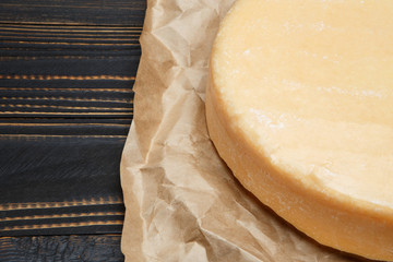 Whole round Head of parmesan or parmigiano hard cheese on wooden background