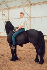 man riding brown horse on the countryside