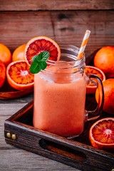 Fresh smoothie with  banana, blood oranges and mint in a mason jar