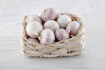 Fresh garlic decorated on a white wooden kitchen plate can be used as background