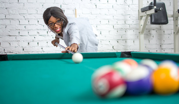 Beautiful young woman playing pool game. - Powered by Adobe