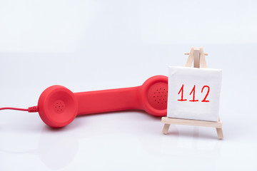Telefon Hörer mit einem Schild für die Notfall Nummer 112