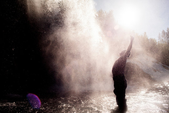 Man enjoying waterfall spray, Ural, Sverdlovsk, Russia
