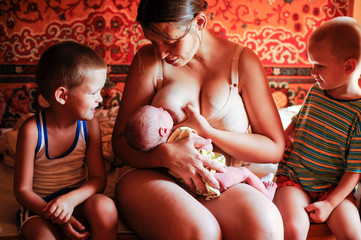 A newly born baby. The first days of life. Happy baby and mom at home. Feeding, wiping, hygienic...