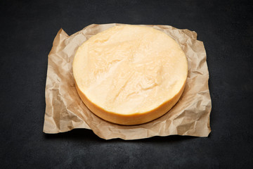 Whole round Head of parmesan or parmigiano hard cheese on concrete background