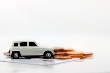 Miniature car model on credit card with coins. Concept of money, finance and car loan.