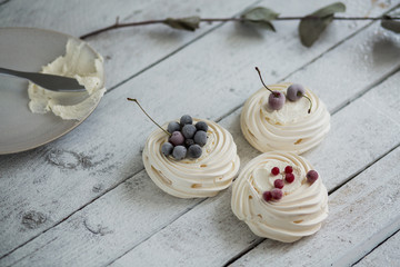 Pavlova cakes with cream and freezed berries. Pastel colors and small bouquet of lavender. Background of white boards. - 191995206
