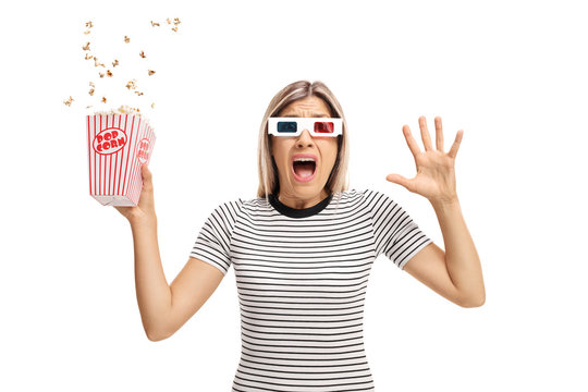 Terrified young woman with 3D glasses and popcorn