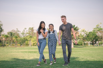 Happy young couple spending time with their daughter in park.The concept of a happy family.
