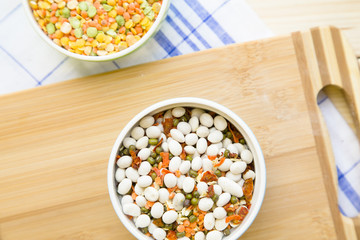 Set of raw ingredients for Italian cooking on a table. Beans on a cutting board. Set of healthy food products. Closeup, top view