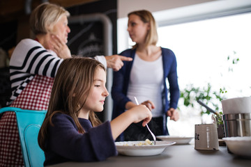A small girl with mother and grandmother at home.