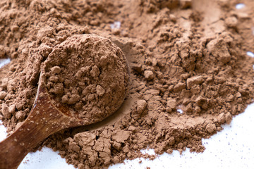 pile cocoa powder in a scoop isolated on white. heap of fresh of chocolate studio shot