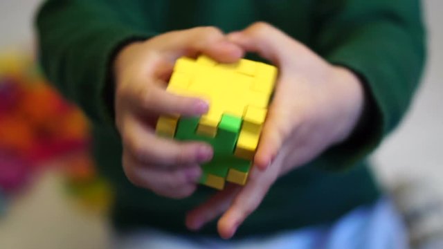 little boy holding a toy cube