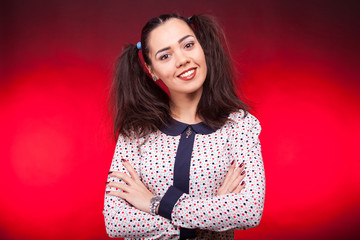 Fototapeta premium Portrait of beautiful woman smiling and looking at the camera on dark red background