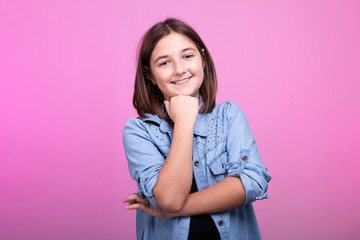 Fototapeta premium Portrait of happy smiling teenager on pink background in studio photo