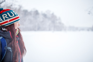 Portrait of side view of woman with long hair in winter forest