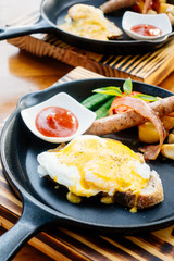 Egg benedict with sausage bacon and tomato sauce