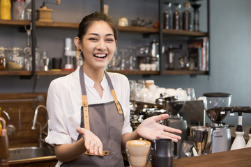Fototapeta na wymiar Asian barista woman make a coffee at bar. Woman success to make coffee.