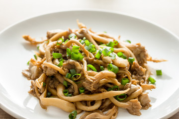 Shimeji mushroom and chives on white plate. Japanese food. Detail of food dish, closeup, selective focus.