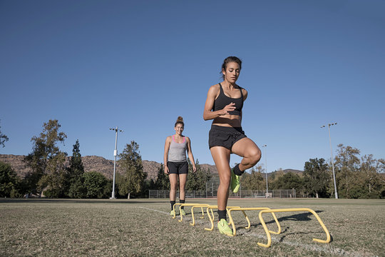 Woman Jumping Over Agility Hurdles