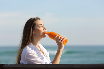 Femme buvant un jus d& 39 orange sur la plage