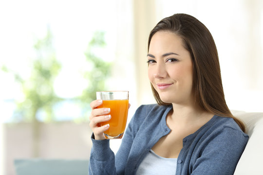 Serious woman holding a glass of orange juice