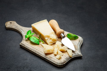Pieces of parmesan cheese on concrete background