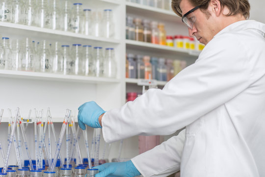 Lab worker taking dye from beaker using long pipette