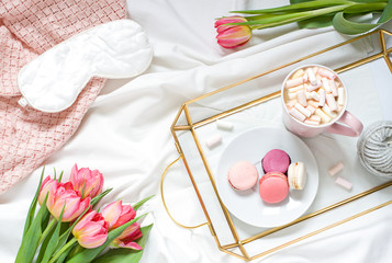 Breakfast in bed pastel flat lay composition with flowers, a cup o coffee  and sweets. Concept woman's or mother's day top view