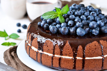 Homemade chocolate cake with cream and blueberries on a white background. Happy Birthday.