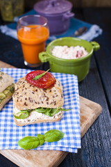 Sandwiches with fresh Italian rolls with avocado, basil, tomatoes and soft cheese. Breakfast healthy eating on a dark background. Free place for text or postcard.