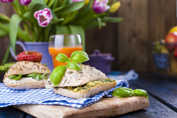 Sandwiches with fresh Italian rolls with avocado, basil, tomatoes and soft cheese. Breakfast healthy eating on a dark background. Free place for text or postcard.