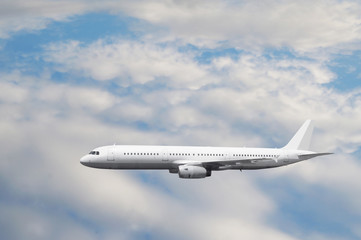 Obraz premium The white passenger plane flies against a slightly cloudy sky