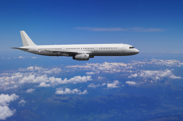 Fototapeta na wymiar A passenger plane is flying over a mountainous landscape
