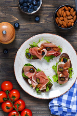 Toast of rye bread with jamon, blueberries and almonds. Snack with a proshoto!