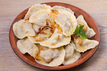 Dumplings, filled with beef meat and served with fried onion. Varenyky, vareniki, pierogi, pyrohy. Dumplings with filling