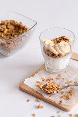 Ingredients for homemade oatmeal granola in glass jar. Oat flakes, honey, raisins and nuts. Healthy breakfast concept with copy