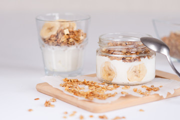 Ingredients for homemade oatmeal granola in glass jar. Oat flakes, honey, raisins and nuts. Healthy breakfast concept with copy