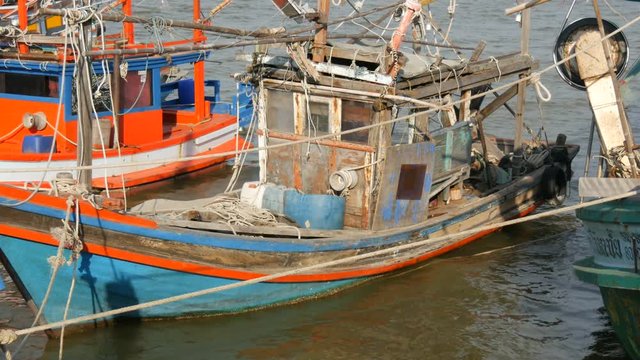 PATTAYA, THAILAND - DECEMBER 25, 2017: A large number of wooden fishing boats are moored on quay