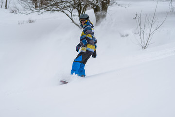 Snowboarder rides, in a cloud of snow, during freeride