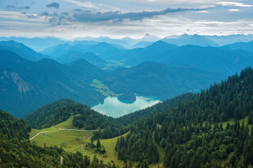Fototapeta na wymiar Mountain view with forests, green meadows and Walchensee lake