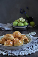 Half of apples baked in dough, buns with apples. Dark background. Decorated with fresh green apples