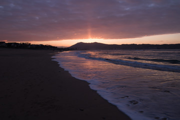 Fototapeta na wymiar mountain Jaizkibel backlit on atlantic coastline in beautiful red golden sunset, hendaye, france
